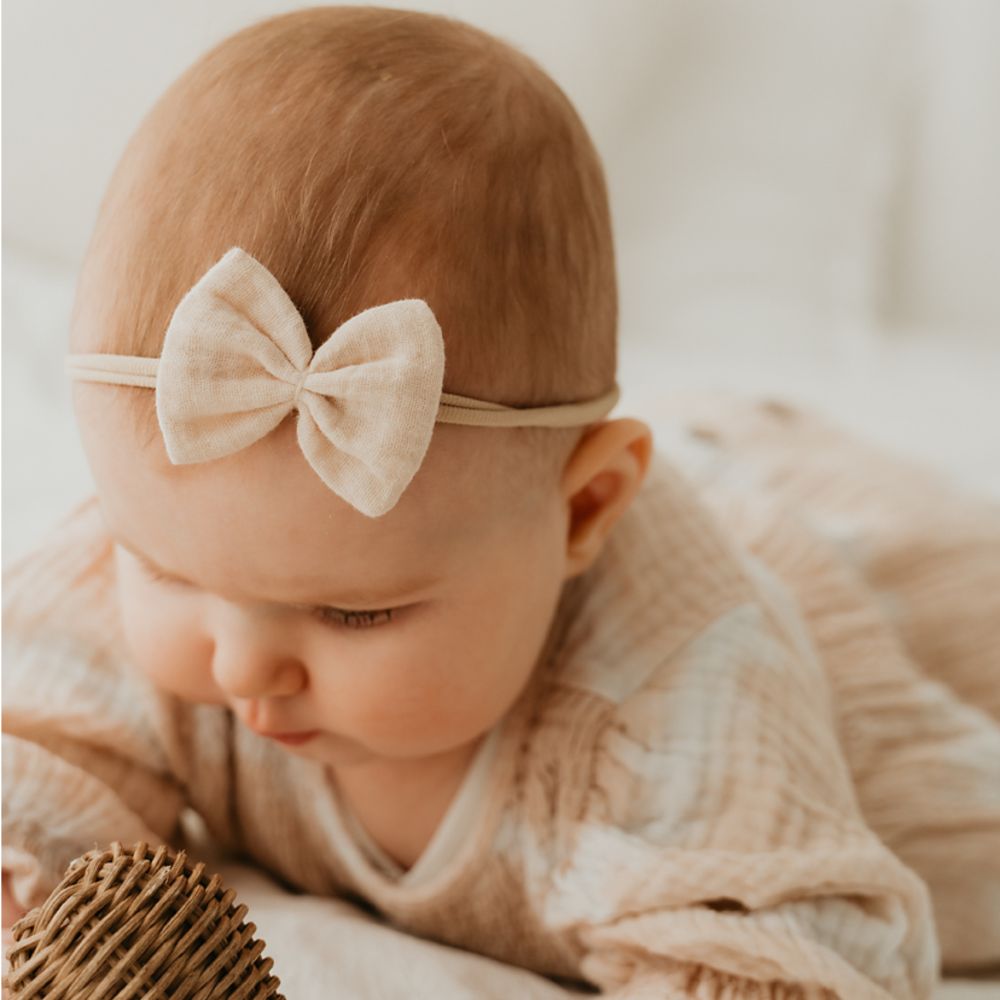 Baby mit Haarschleife in beige an Haarband