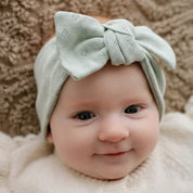 Baby mit Stirnband in mint