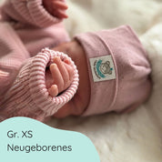 Neugeborenes mit  Beanie aus weicher Baumwolle mit feinem Lochmuster für Babys in hellrosa