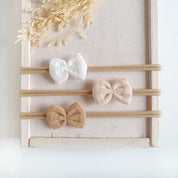 Haarschleifen für Babys im Set in den Farben weiß, beige und sand an einem elastischen Haarband