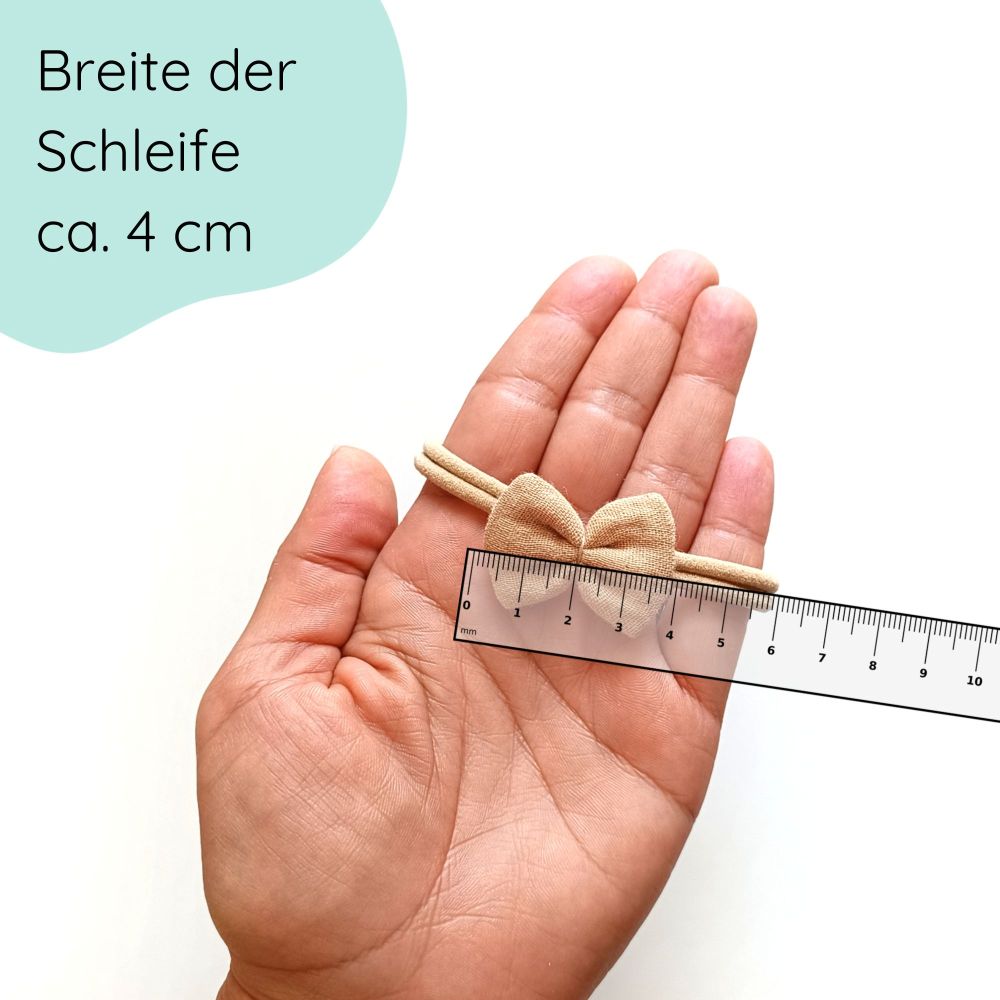Detaillbild Haarschleife aus Musselin für Babys in der Farbe Sand an einem elastischen Haarband