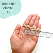 Detaillbild Haarschleife aus Musselin für Babys in der Farbe Sand an einem elastischen Haarband
