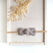 kleine Haarschleife in taupe aus Musselin an einem elastischen Haarband