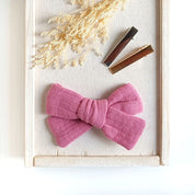 große Haarschleife aus Musselin in rosa an einem Alligatorclip in gold oder silber