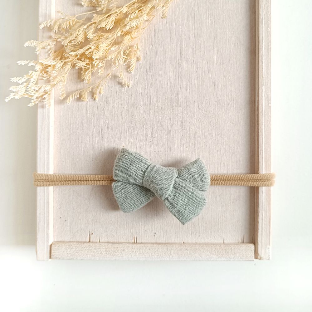 Haarschleife für Babys aus Musselin in mint an einem elastischen Haarband