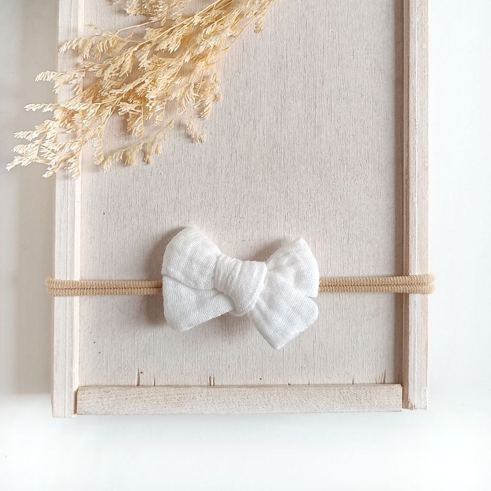weiße Haarschleife für Babys aus Musselin an einem elastischen Haarband