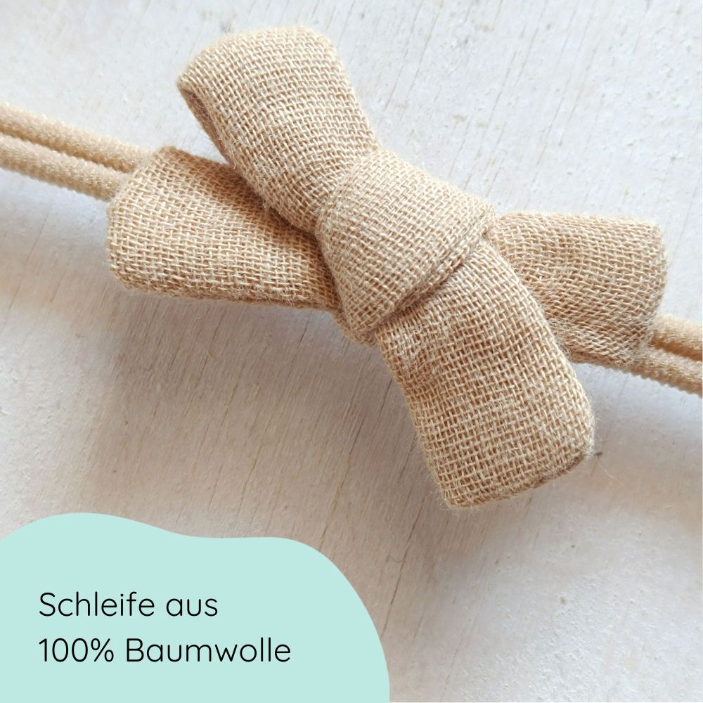 kleine Haarschleife aus Musselin für Babys in der Farbe sand an einem Haarband Detailbild