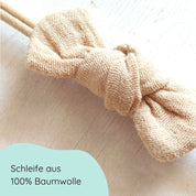 Haarschleife aus Musselin für Babys in der Farbe beige an einem elastischen Haarband Detailbild