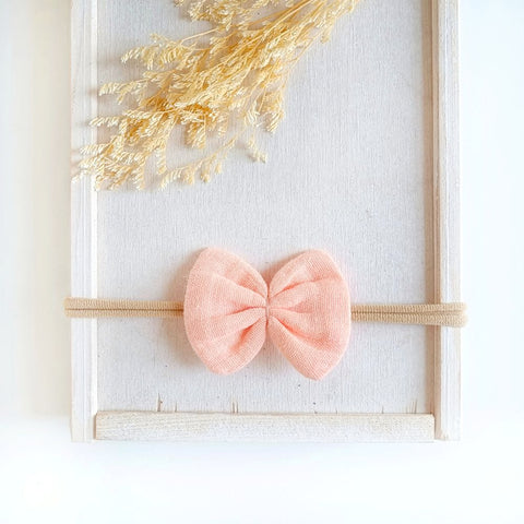 Haarschleife aus Musselin für Babys in nude an einem elastischen Haarband