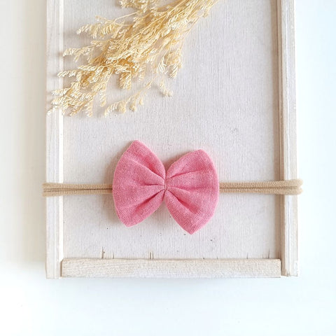 Haarschleife für Babys aus Musselin in pinkrose an einem elastischen Haarband