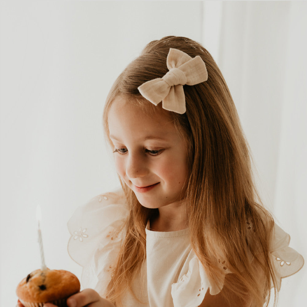 Mädchen mit großer Haarschleife in beige