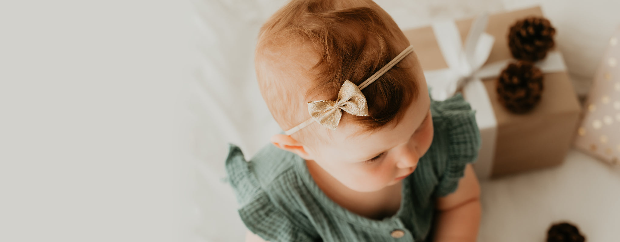 Baby mit goldener Schleife an Haarband