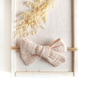 große Haarschleife für Babys aus Musselin in beige an einem elastischen Haarband